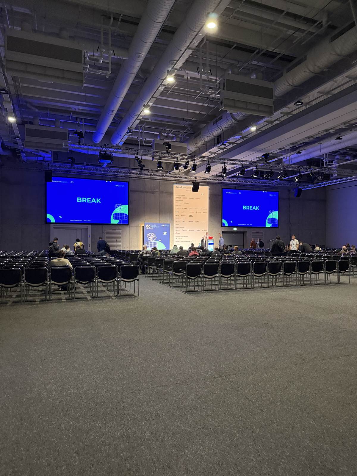 The main hall with BREAK on the screens and empty chairs