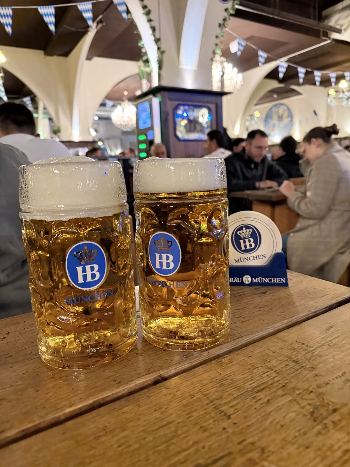 Two one-litre Hofbräu beers on a wooden table