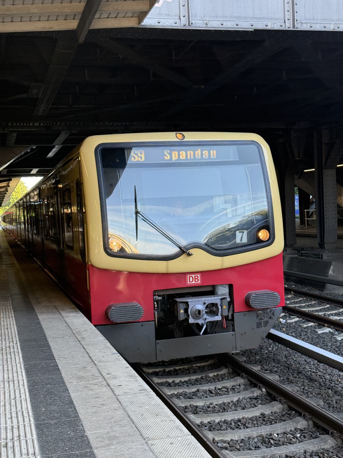 A red and yellow S-Bahn train pulling into the platform