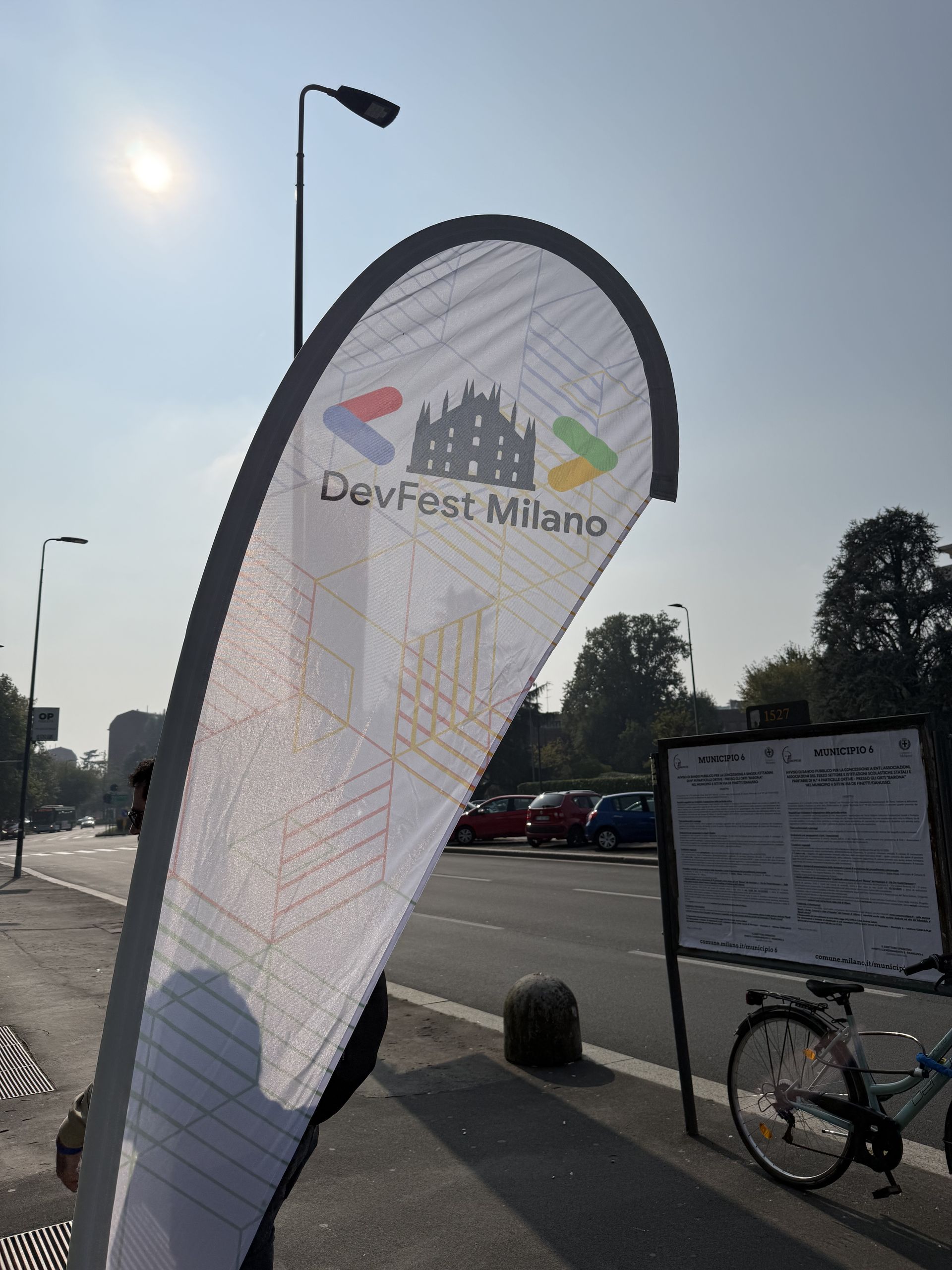 The DevFest Milano teardrop flag outside the venue with the Duomo logo on it