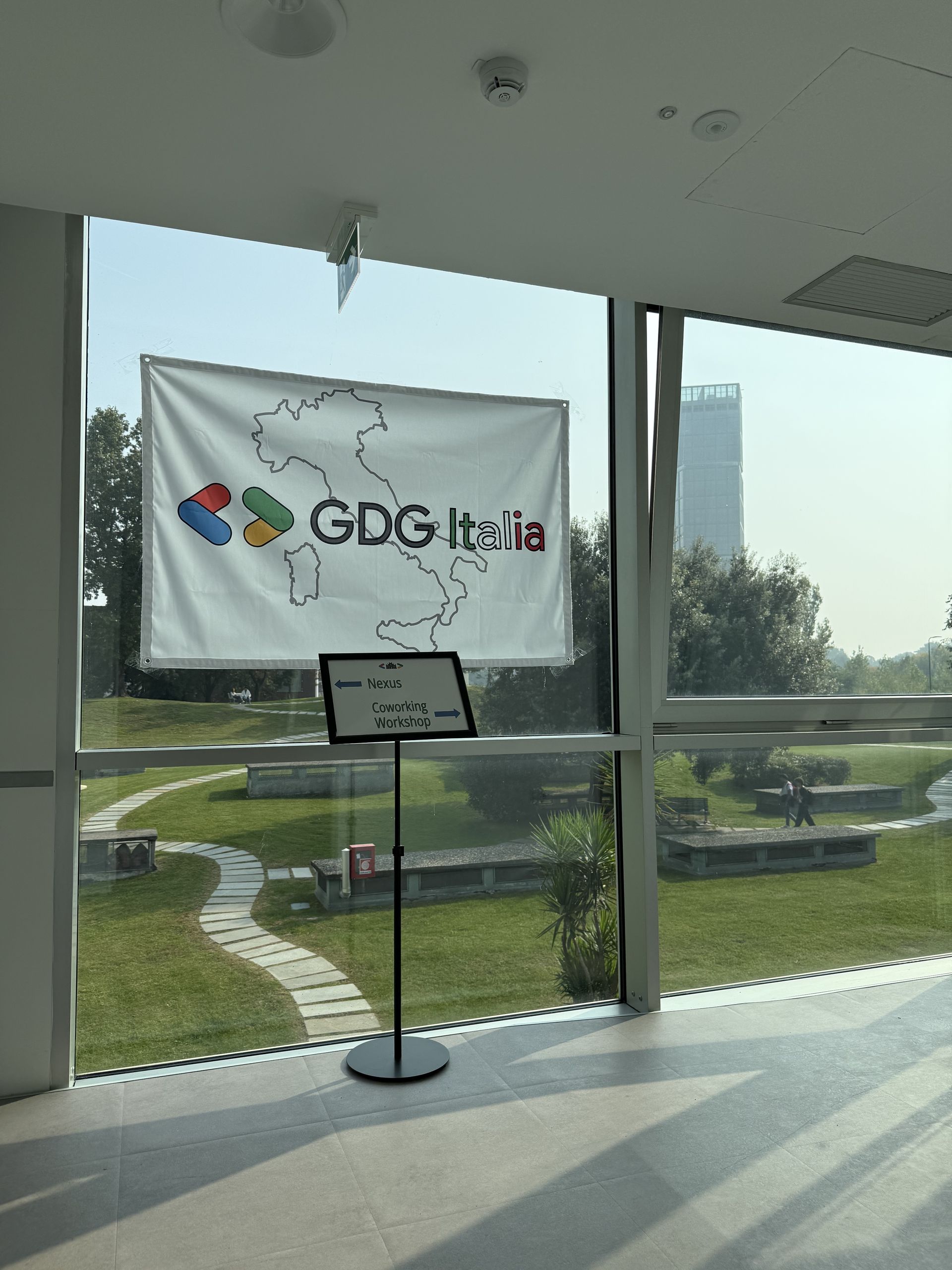 The GDG Italia banner against the window with the park behind it