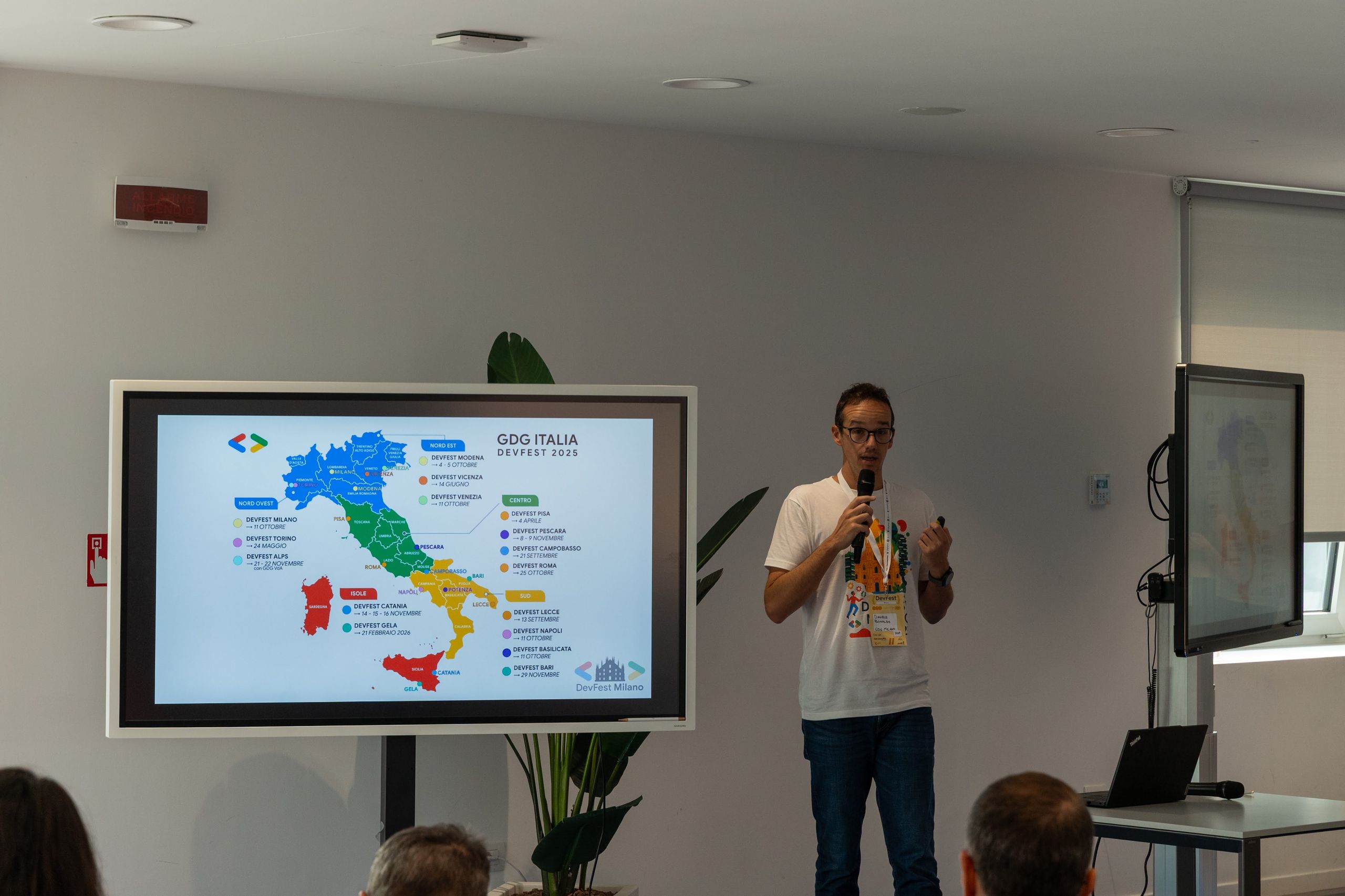 A speaker in front of a slide showing the GDG Italia chapters on a map of Italy