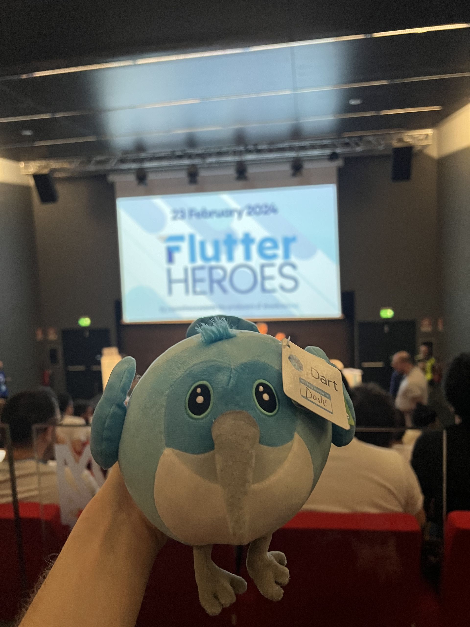 A Dash plush held up inside the auditorium