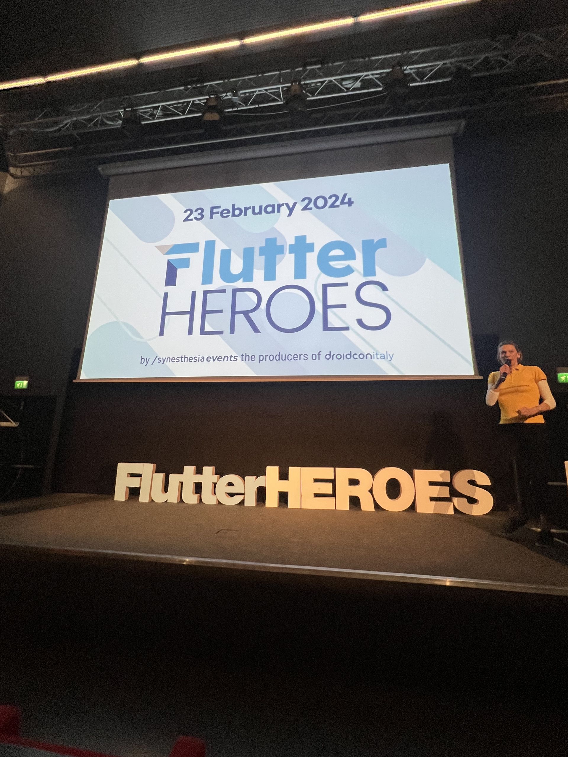 The Flutter Heroes stage seen wide, with the screen and the letters
