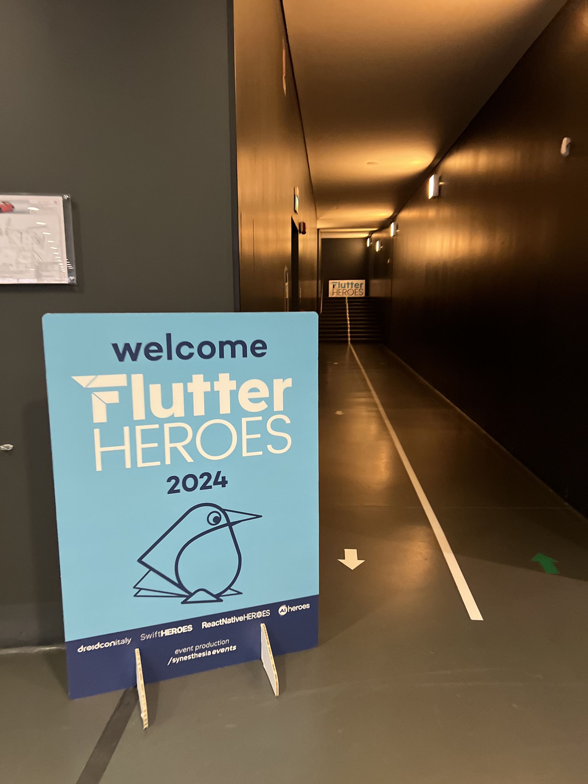 The welcome Flutter Heroes 2024 sign with the line-drawn bird logo