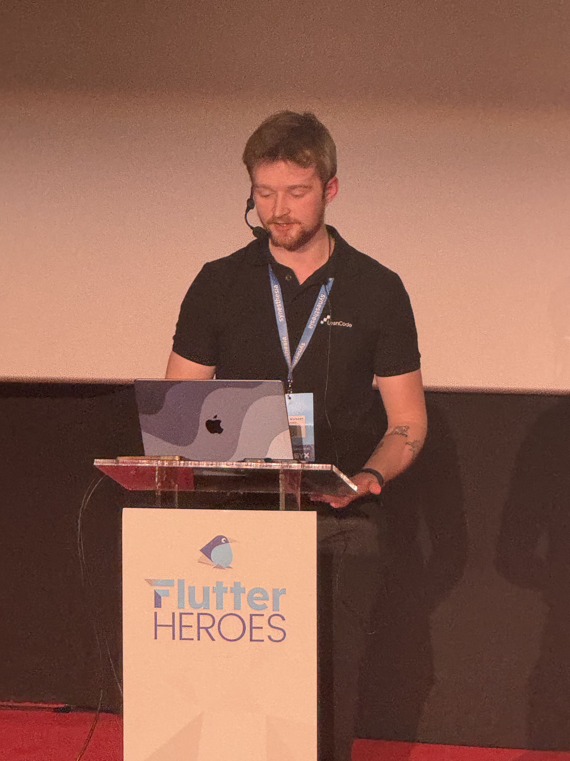 A speaker at the Flutter Heroes lectern with a laptop