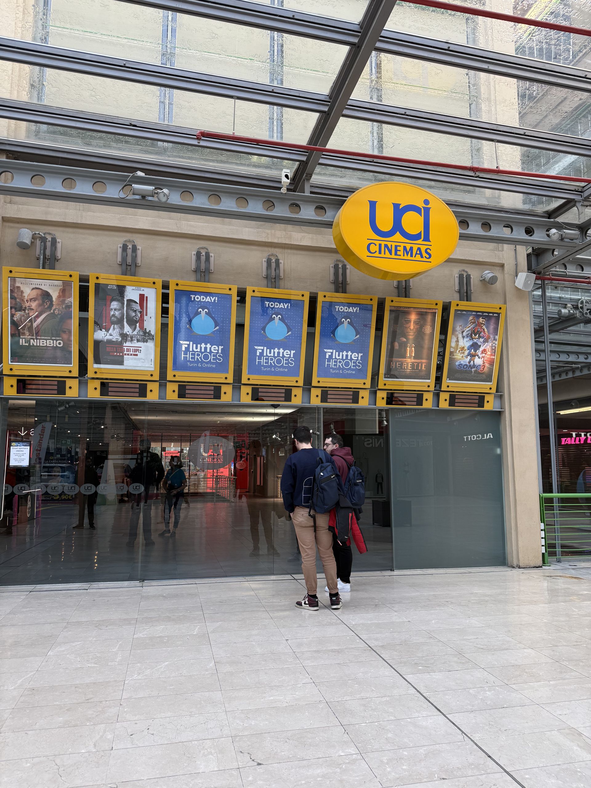 The UCI Cinemas entrance with three Flutter Heroes posters among the film posters