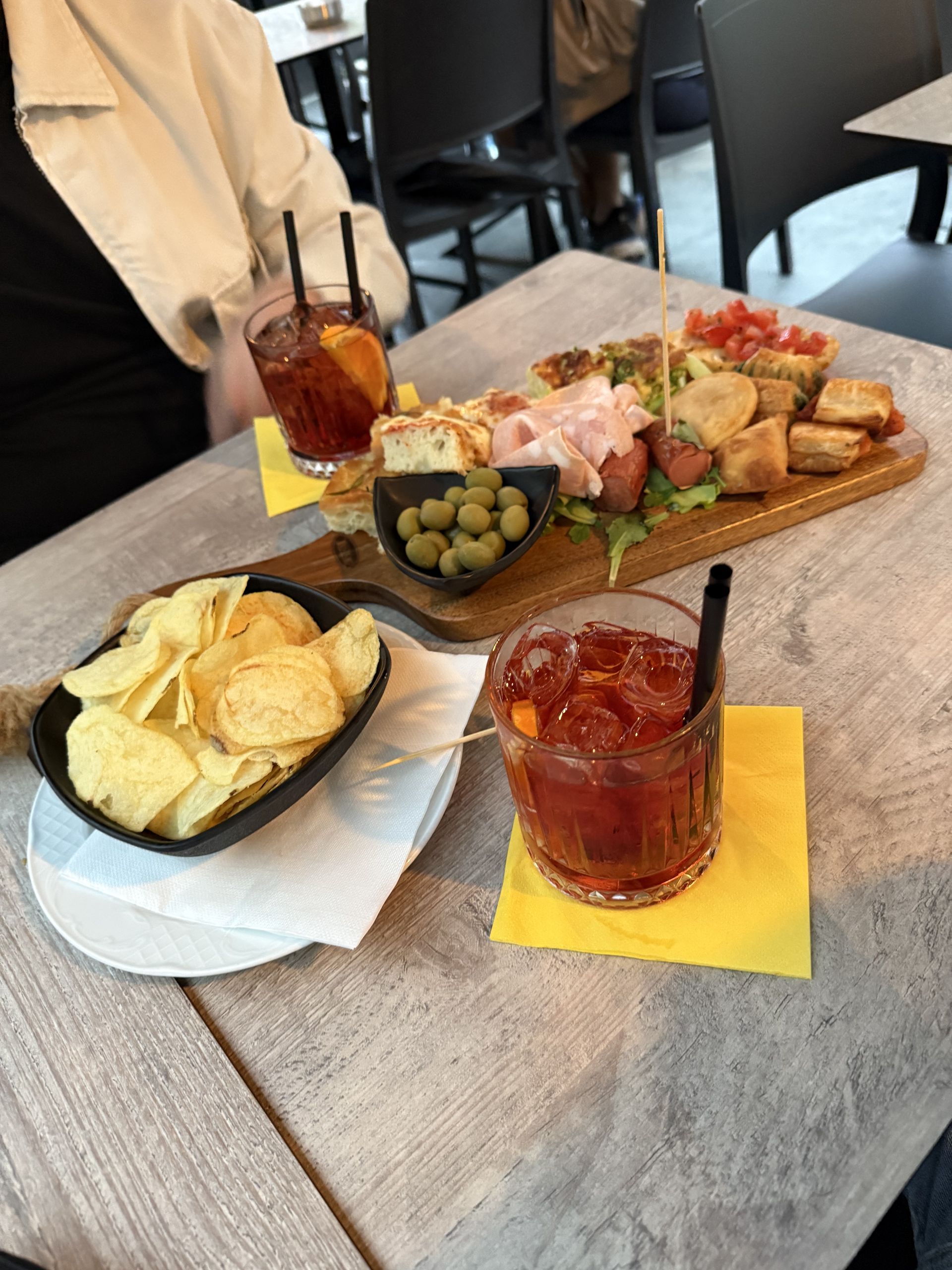 A spritz and a board of aperitivo food on a table before the event