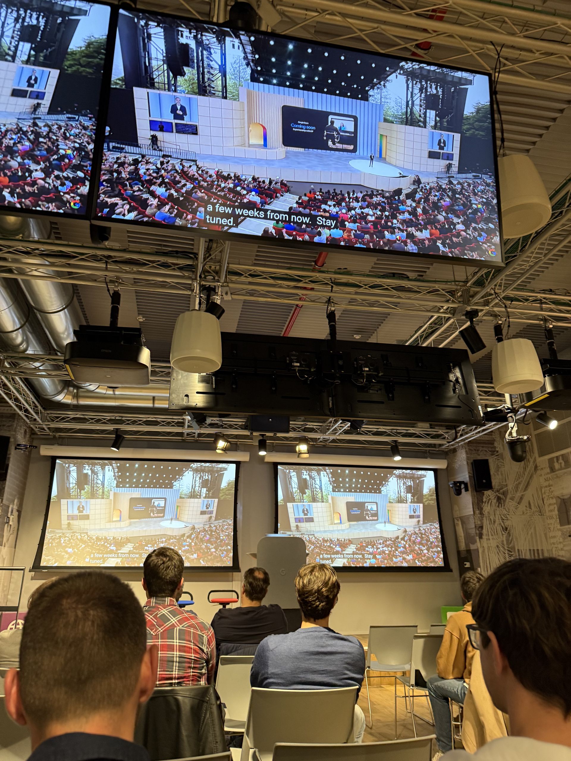 The Shoreline Amphitheatre crowd on the screens during the I/O keynote