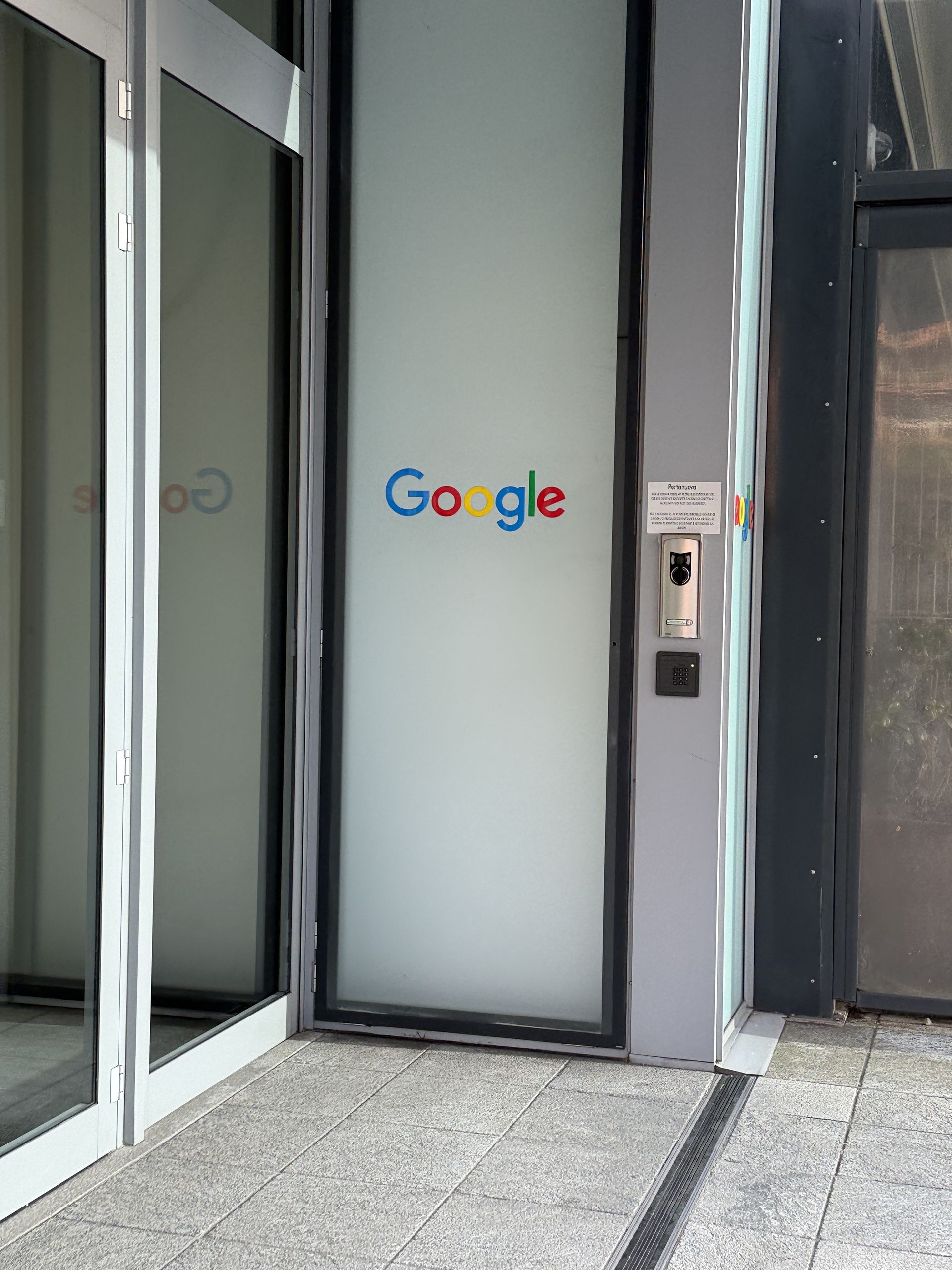 The Google logo on the frosted glass doors of the Milano office