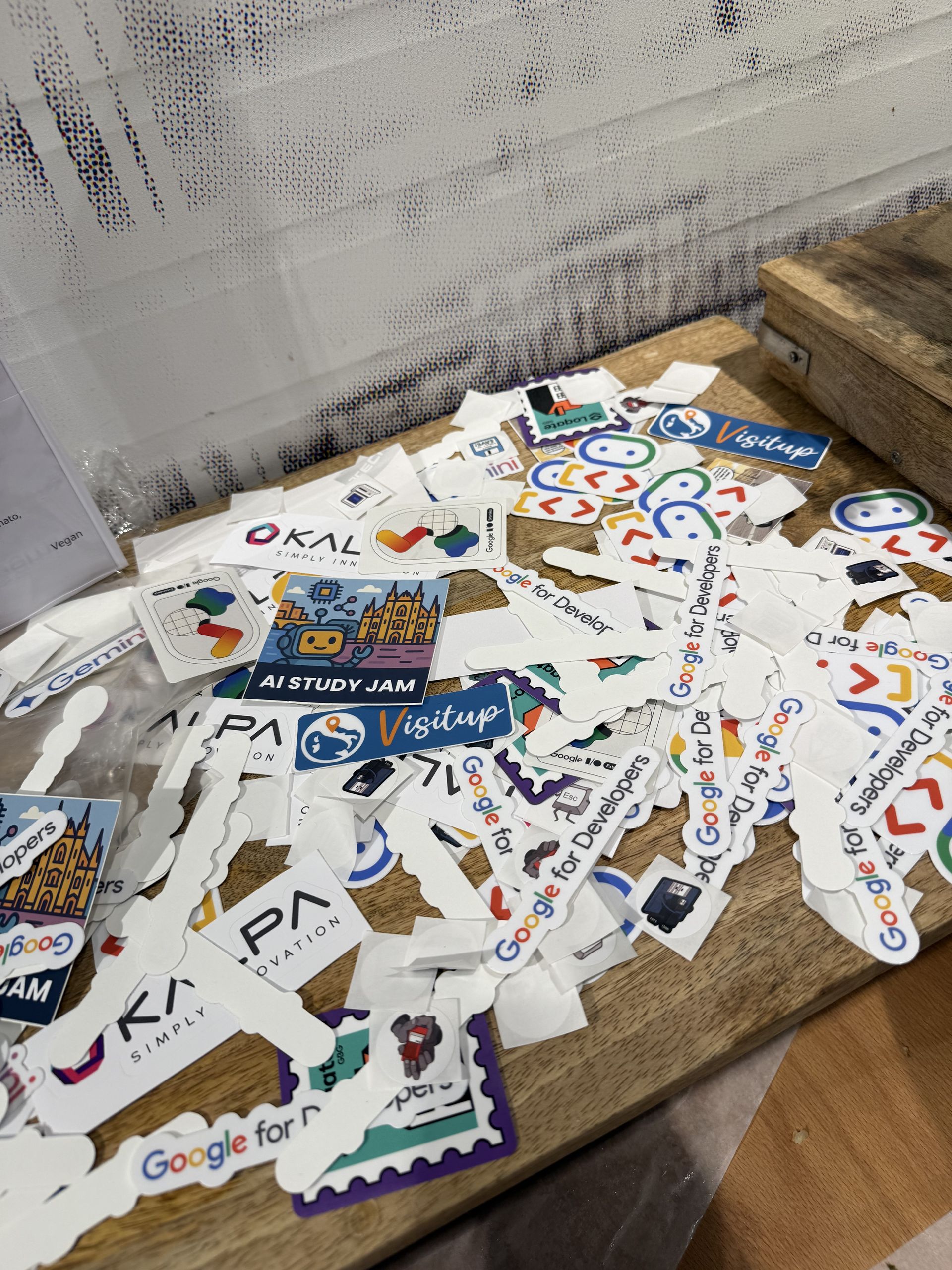 A table covered in developer stickers from Google and the local chapters