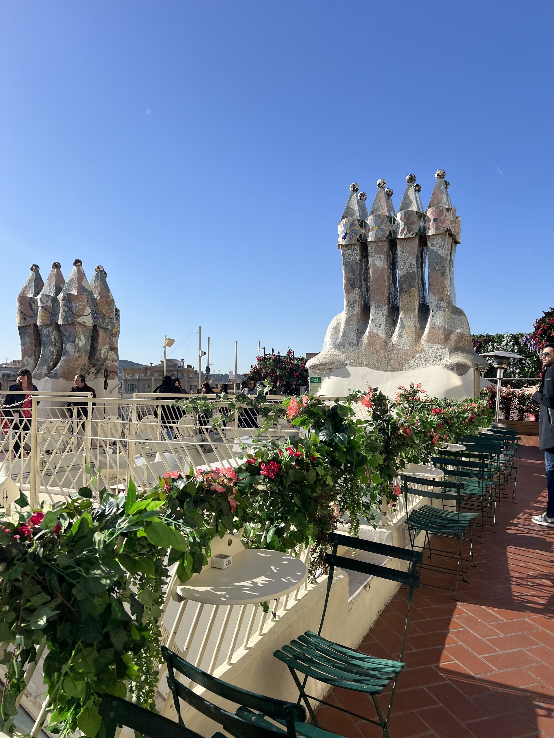 The roof terrace of Casa Batlló with flowers and trencadís chimneys