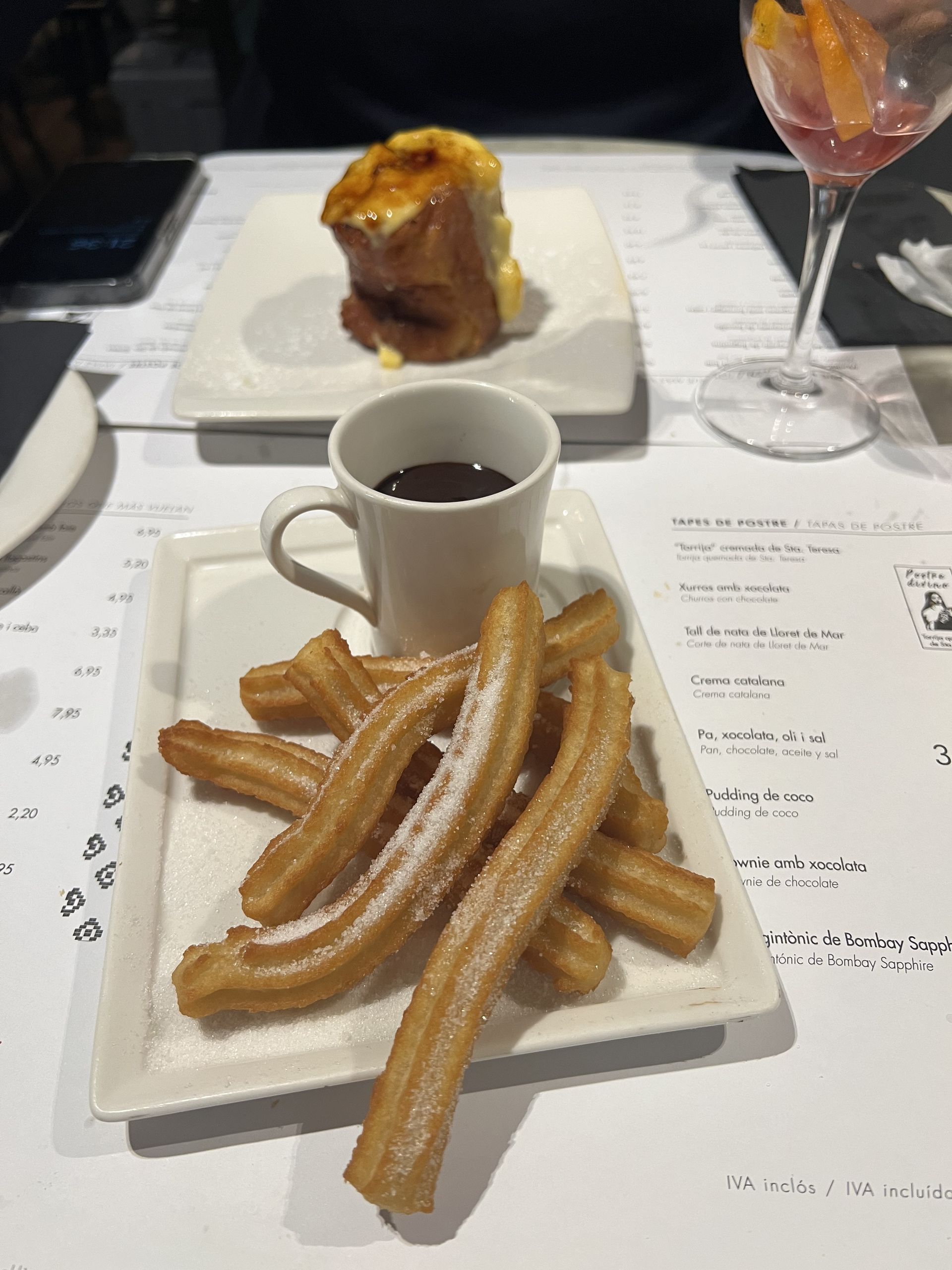 A plate of churros with a cup of hot chocolate
