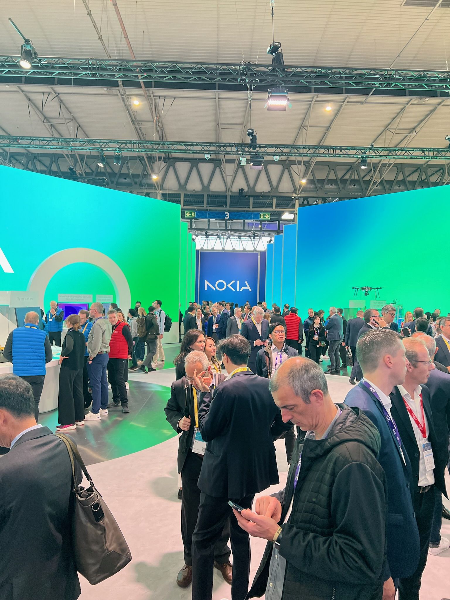 The Nokia stand with green and blue LED walls and a drone above the crowd