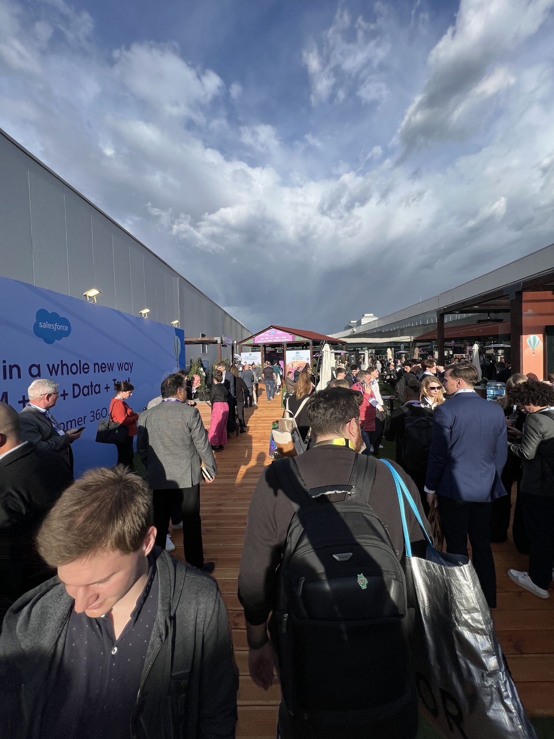 People walking the boardwalk through the Salesforce village