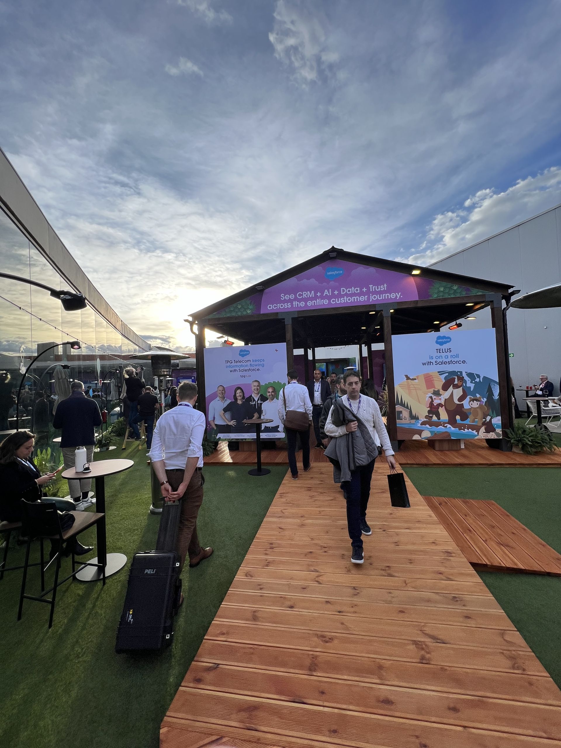The Salesforce village at sunset with people walking the boardwalk