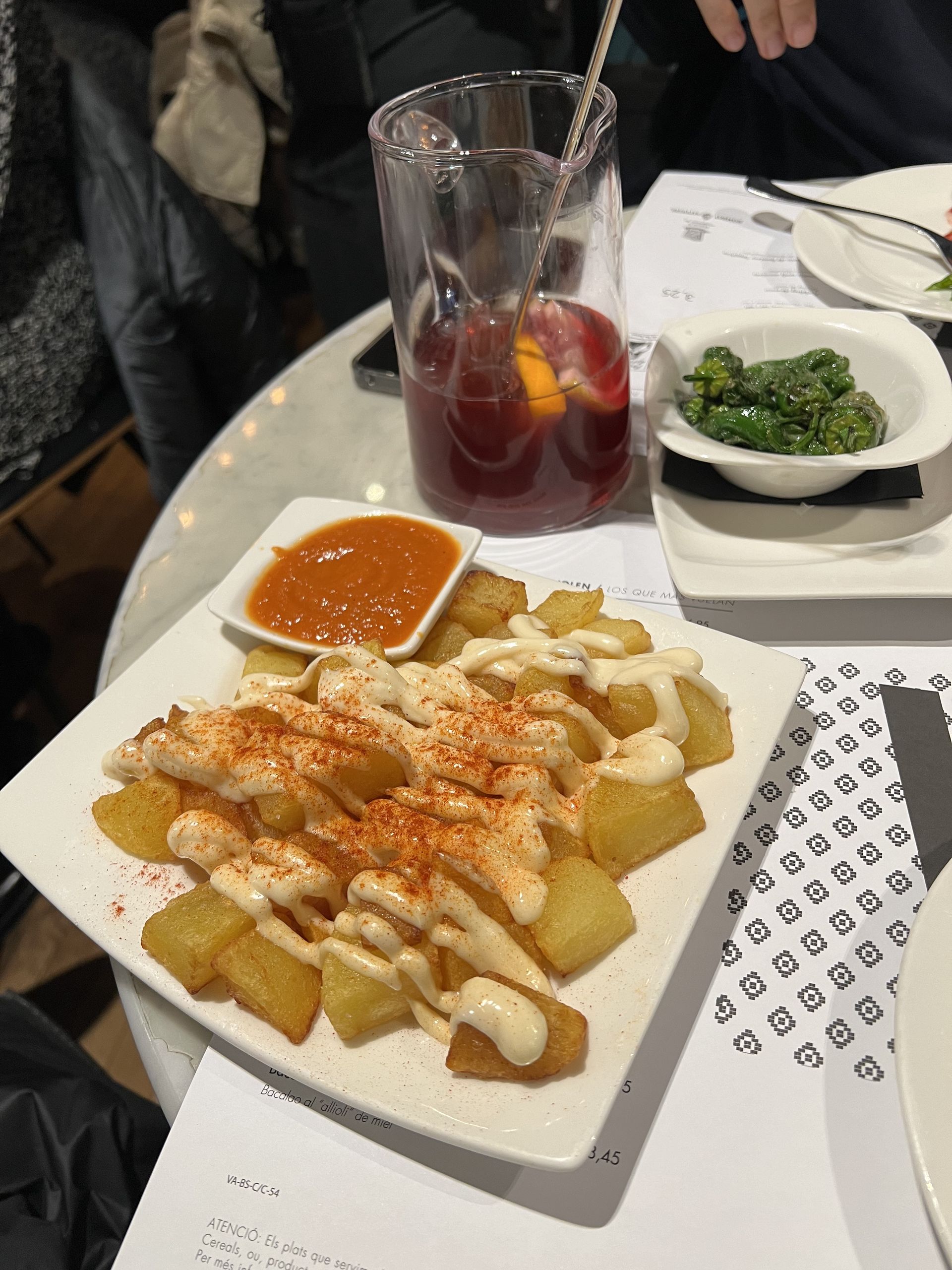 Patatas bravas with a jug of sangria and padrón peppers