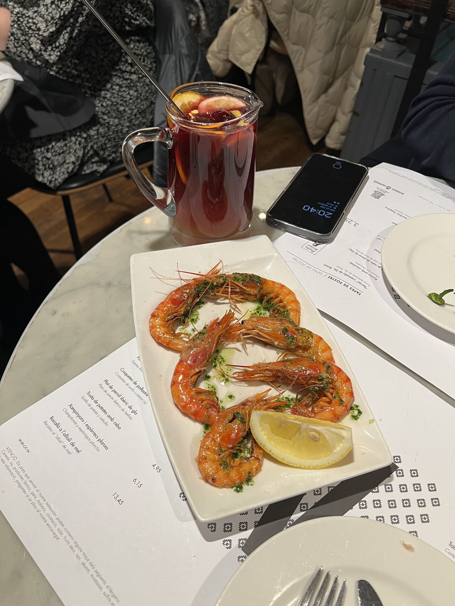 A plate of prawns with lemon at a tapas bar